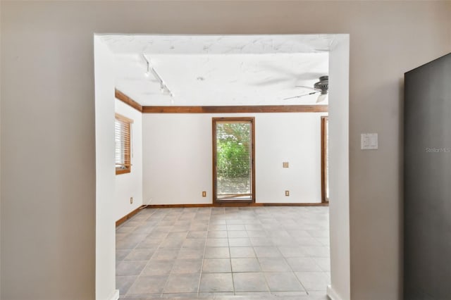 tiled empty room featuring ceiling fan and track lighting