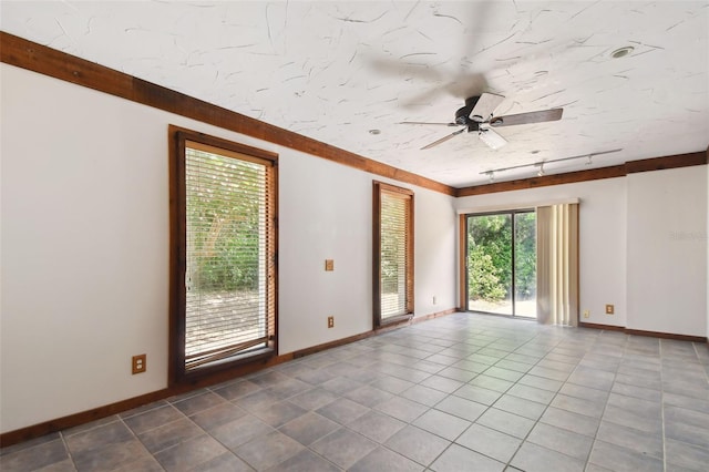 tiled spare room with ceiling fan