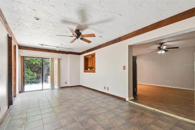 spare room featuring ceiling fan, track lighting, and tile patterned flooring