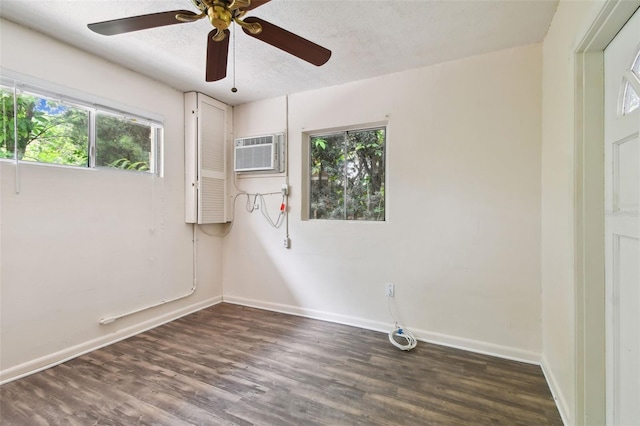 empty room with hardwood / wood-style flooring, a textured ceiling, a wall mounted air conditioner, and ceiling fan