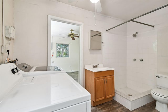 bathroom featuring ceiling fan, toilet, vanity, wood-type flooring, and independent washer and dryer