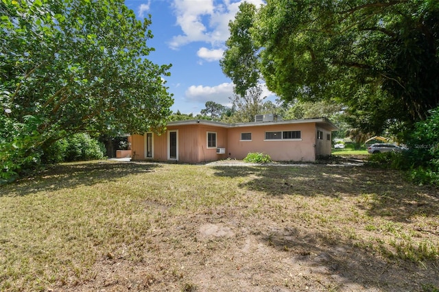 rear view of house featuring a lawn