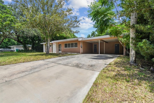 single story home featuring a carport and a front yard