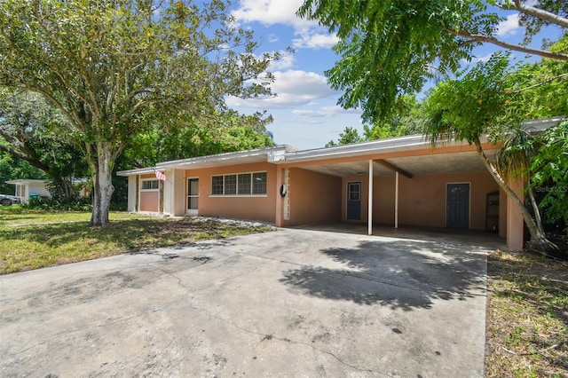 single story home featuring a front yard and a carport