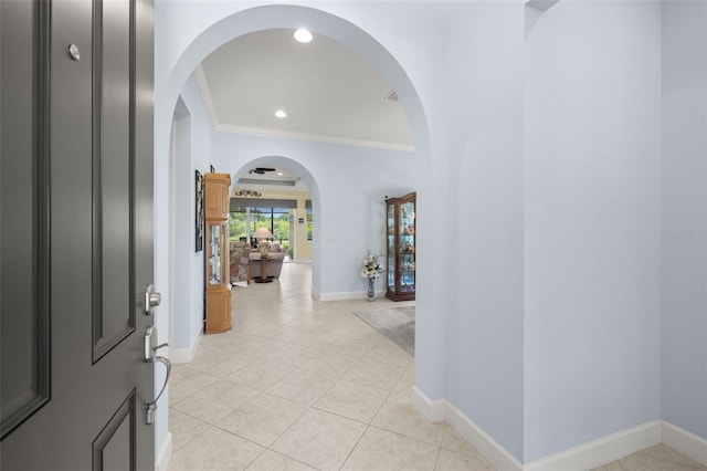 entryway featuring light tile patterned flooring and crown molding