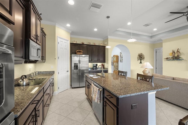 kitchen with a center island with sink, stainless steel appliances, ornamental molding, ceiling fan, and sink