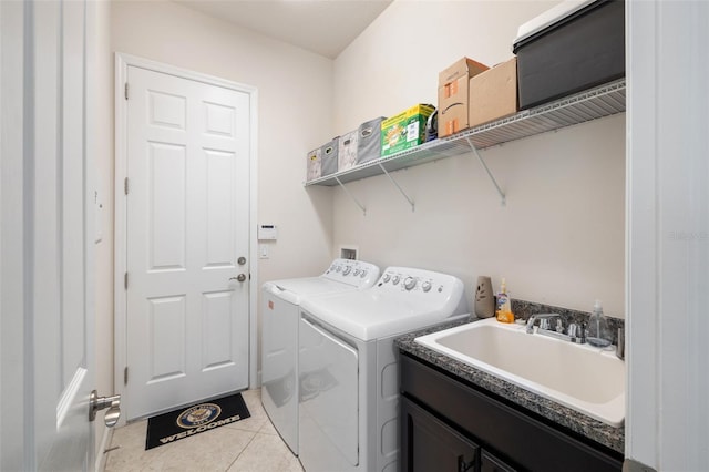 clothes washing area with independent washer and dryer, light tile patterned flooring, sink, and cabinets