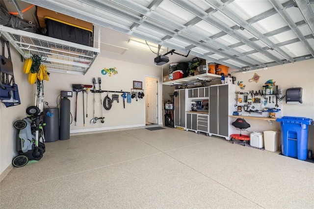 garage featuring gas water heater, a workshop area, and a garage door opener