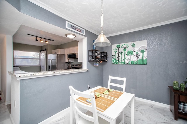 tiled dining space with track lighting, a textured ceiling, and crown molding