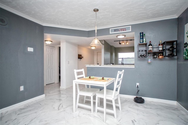 tiled dining room featuring rail lighting, a textured ceiling, and ornamental molding