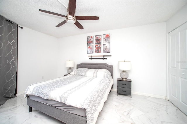 tiled bedroom featuring ceiling fan, a closet, and a textured ceiling