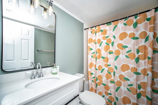 bathroom featuring toilet, vanity, and ornamental molding