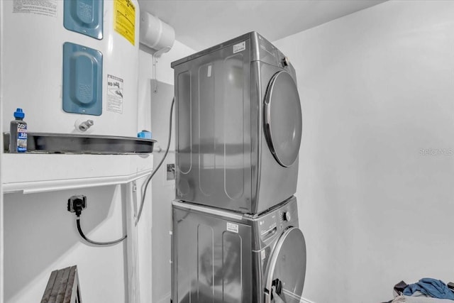 clothes washing area with water heater and stacked washer and clothes dryer