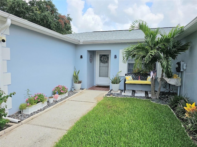 property entrance featuring a lawn