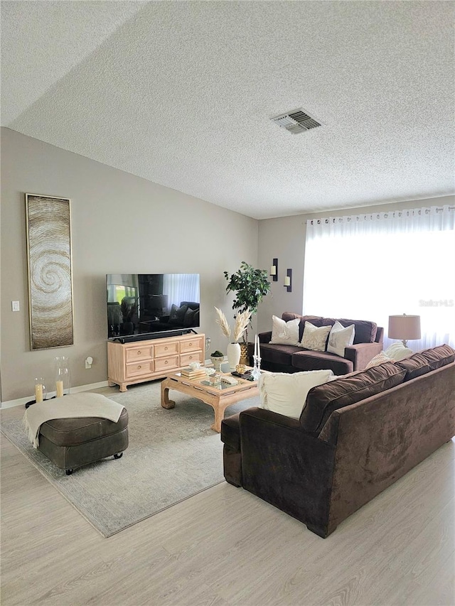 living room featuring a textured ceiling and light hardwood / wood-style floors