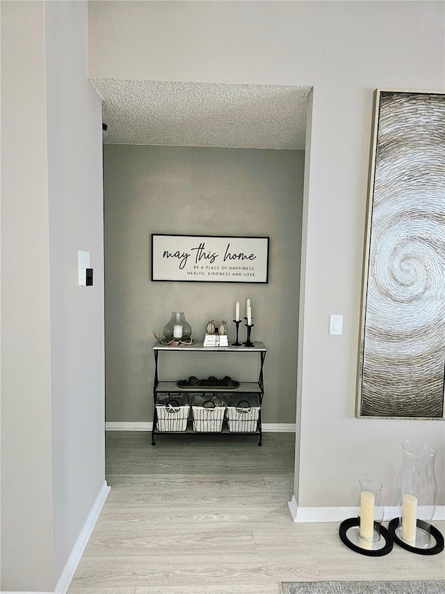 hallway featuring hardwood / wood-style flooring and a textured ceiling