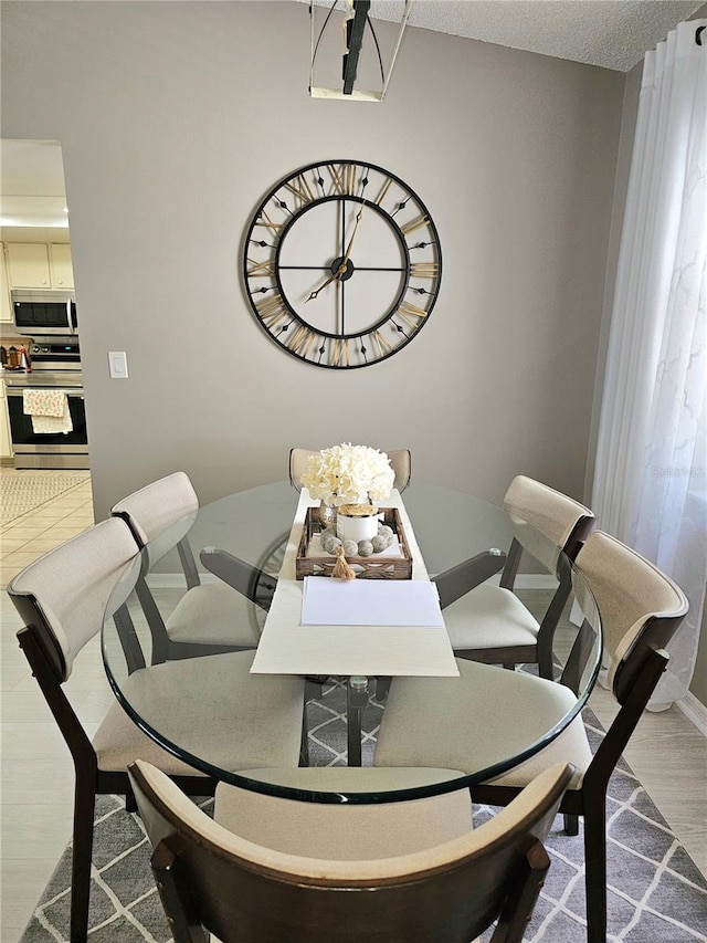 dining area featuring a textured ceiling and light hardwood / wood-style flooring