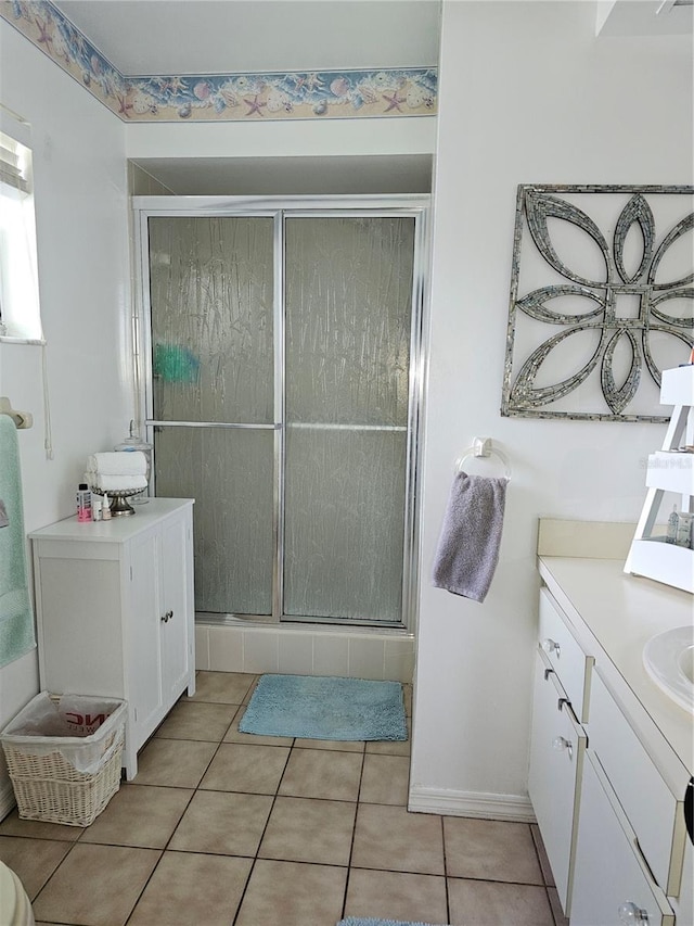 bathroom with vanity, a shower with shower door, and tile patterned flooring