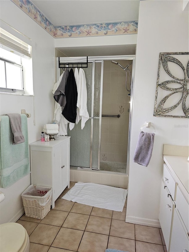 bathroom with vanity, toilet, an enclosed shower, and tile patterned floors