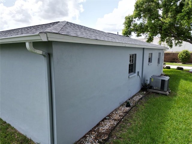 view of side of property featuring a yard and central air condition unit