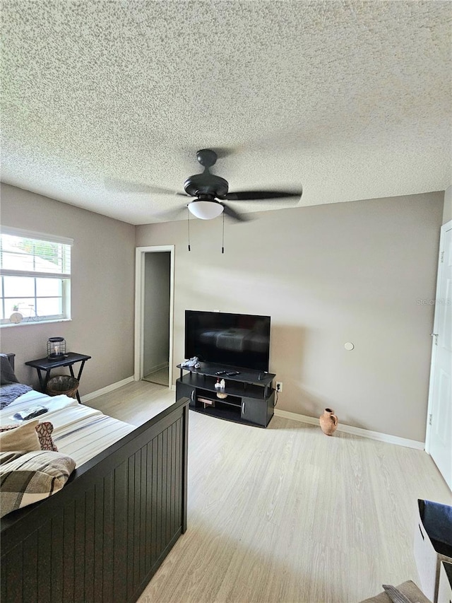 bedroom featuring a textured ceiling, ceiling fan, and light hardwood / wood-style flooring