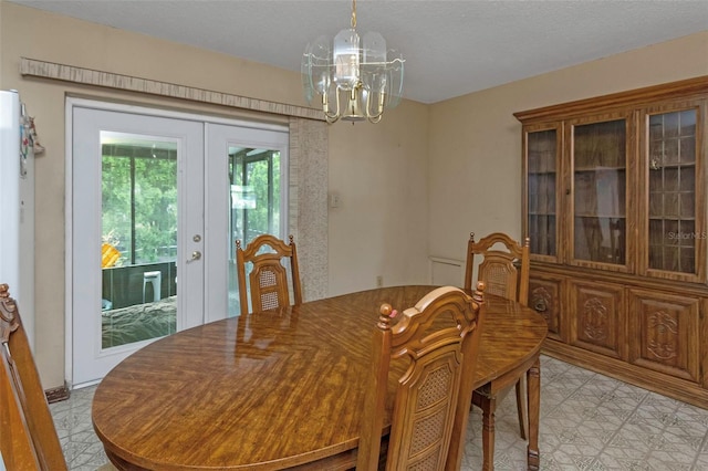 dining area with french doors, light tile patterned floors, and a chandelier