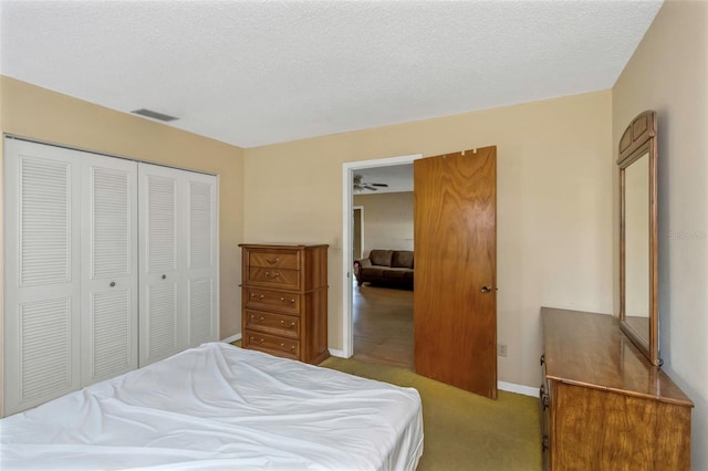 carpeted bedroom with a textured ceiling and a closet