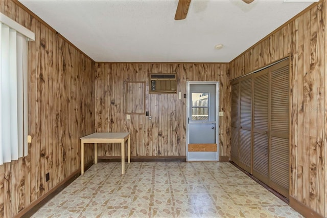 tiled spare room with ceiling fan, a wall unit AC, and wooden walls