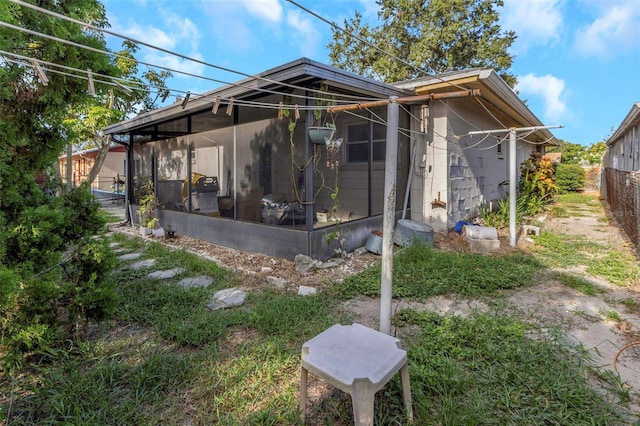 rear view of property featuring a sunroom