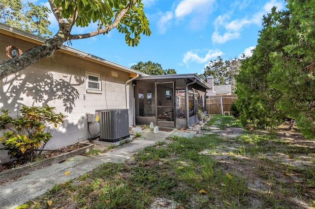 view of yard featuring a sunroom and central AC unit