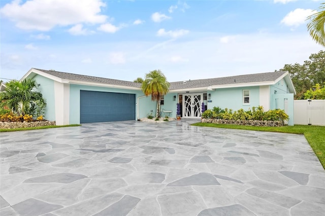 single story home featuring stucco siding, a gate, fence, concrete driveway, and an attached garage