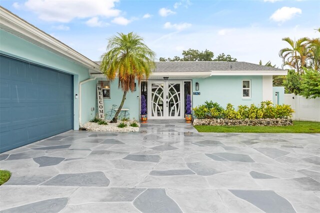 view of front of home with a garage and french doors