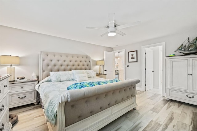 bedroom featuring light hardwood / wood-style flooring, ceiling fan, and connected bathroom