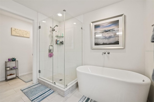 bathroom featuring a soaking tub, a shower stall, and baseboards
