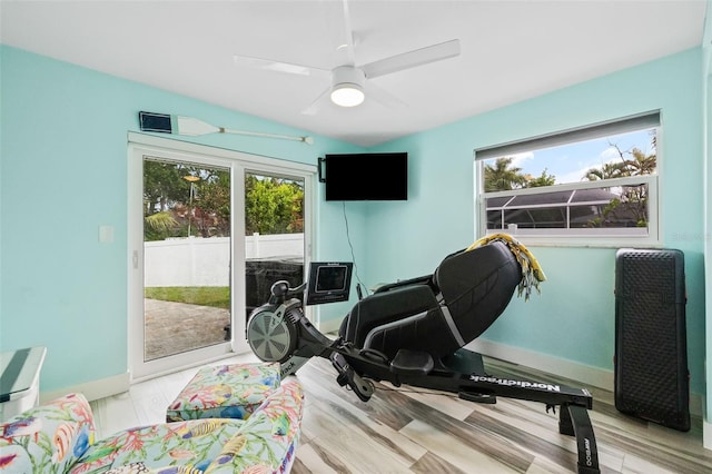 interior space with a healthy amount of sunlight, baseboards, ceiling fan, and vaulted ceiling