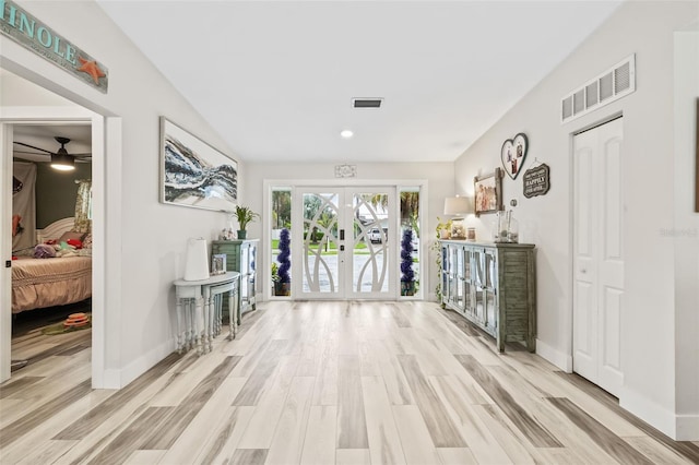 hall with light hardwood / wood-style flooring and french doors