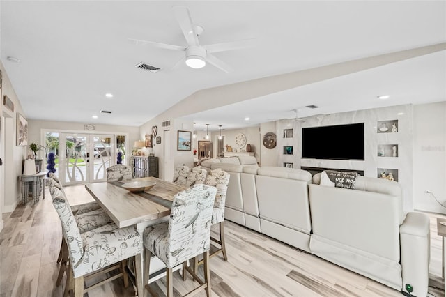 dining area featuring visible vents, vaulted ceiling, light wood-style flooring, french doors, and a ceiling fan