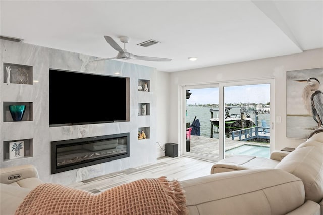 living room with a fireplace, ceiling fan, and hardwood / wood-style flooring