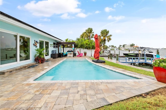 view of pool with a patio and a dock