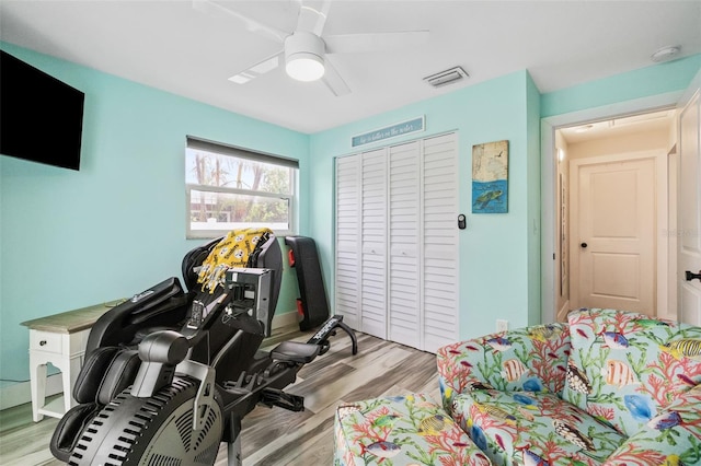 workout room with light hardwood / wood-style flooring and ceiling fan