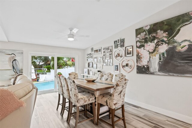 dining area featuring light hardwood / wood-style floors, ceiling fan, and lofted ceiling