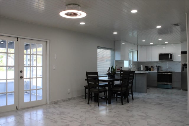 tiled dining space featuring french doors and sink