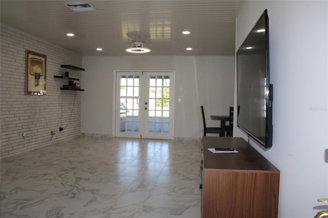 kitchen with french doors, tile patterned flooring, and brick wall