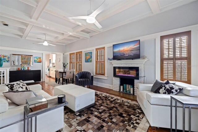 living room featuring beam ceiling, coffered ceiling, hardwood / wood-style floors, and ceiling fan