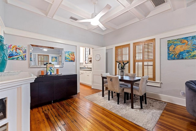 dining area featuring wood-type flooring, visible vents, and coffered ceiling