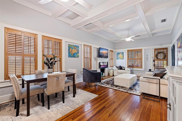 dining room featuring ceiling fan, hardwood / wood-style floors, coffered ceiling, and a healthy amount of sunlight