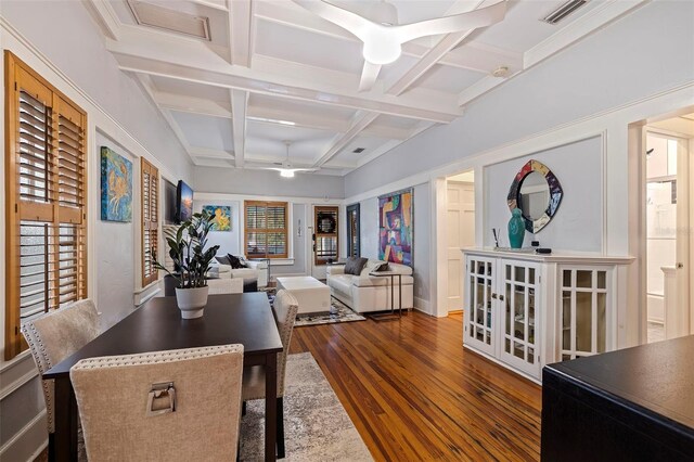 dining area featuring beam ceiling, ceiling fan, coffered ceiling, and dark wood-type flooring