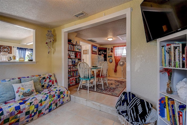 interior space with a healthy amount of sunlight, a textured ceiling, and light tile patterned floors