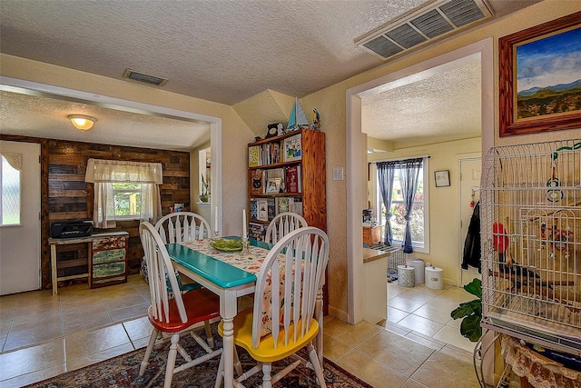 tiled dining room with a textured ceiling