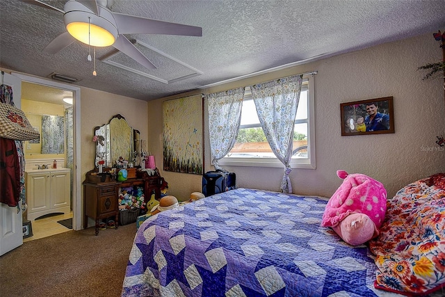 carpeted bedroom featuring ceiling fan, ensuite bath, and a textured ceiling